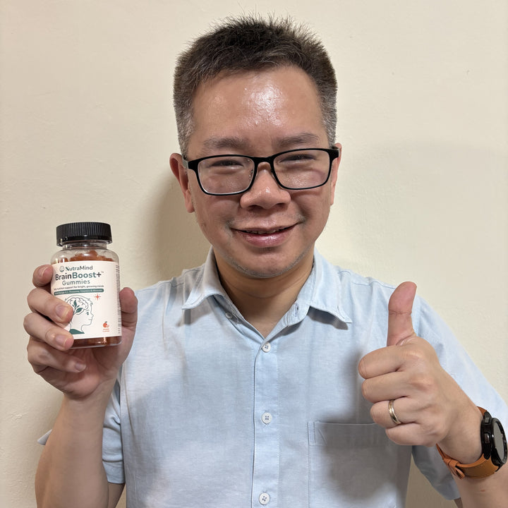 A customer holding a bottle of BrainBoost+ gummies and giving a thumbs up