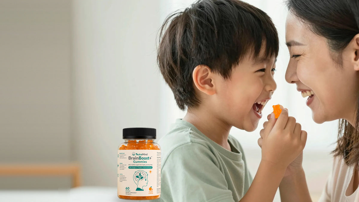 A mother and her young son laughing together as he holds a BrainBoost+™ gummy